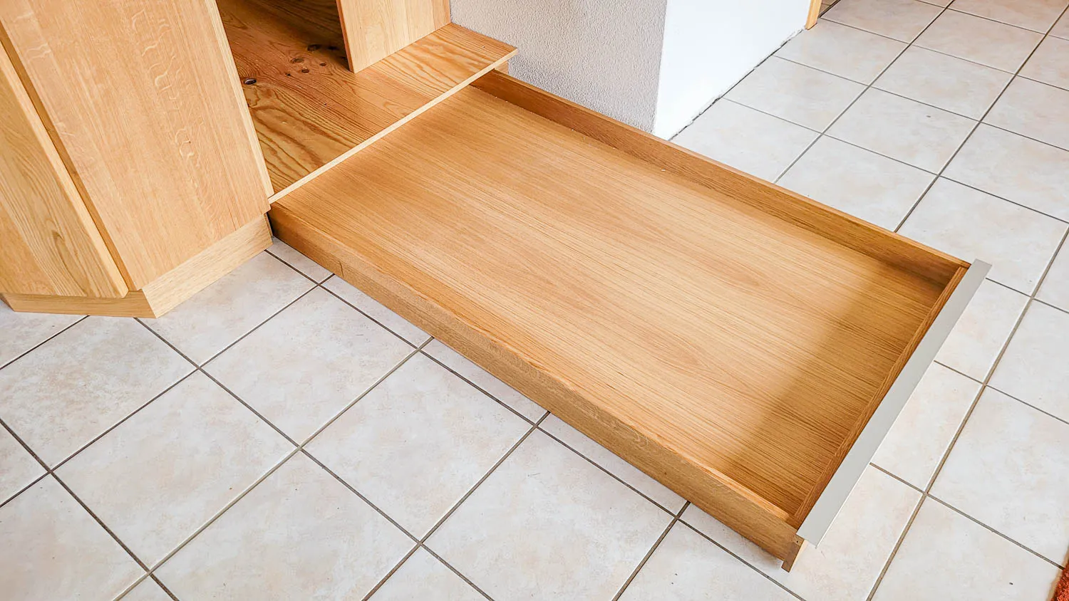 Breiter, vollständig ausgezogener Holzschubladen-Auszug aus heller Buche/Erle.