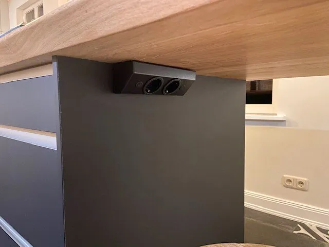 Versteckte Steckdosen unter der Holz-Esstheke der Kochinsel