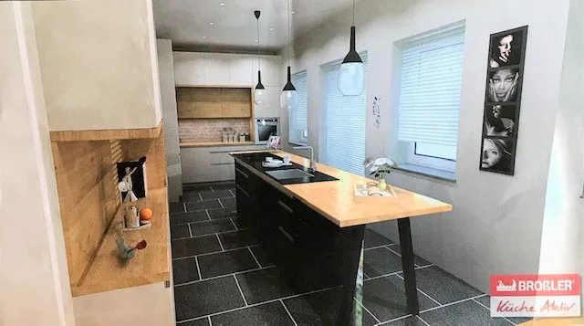 Wohnküche mit Kochinsel, vorgesetzter Holz-Esstheke und Backstein-Nische