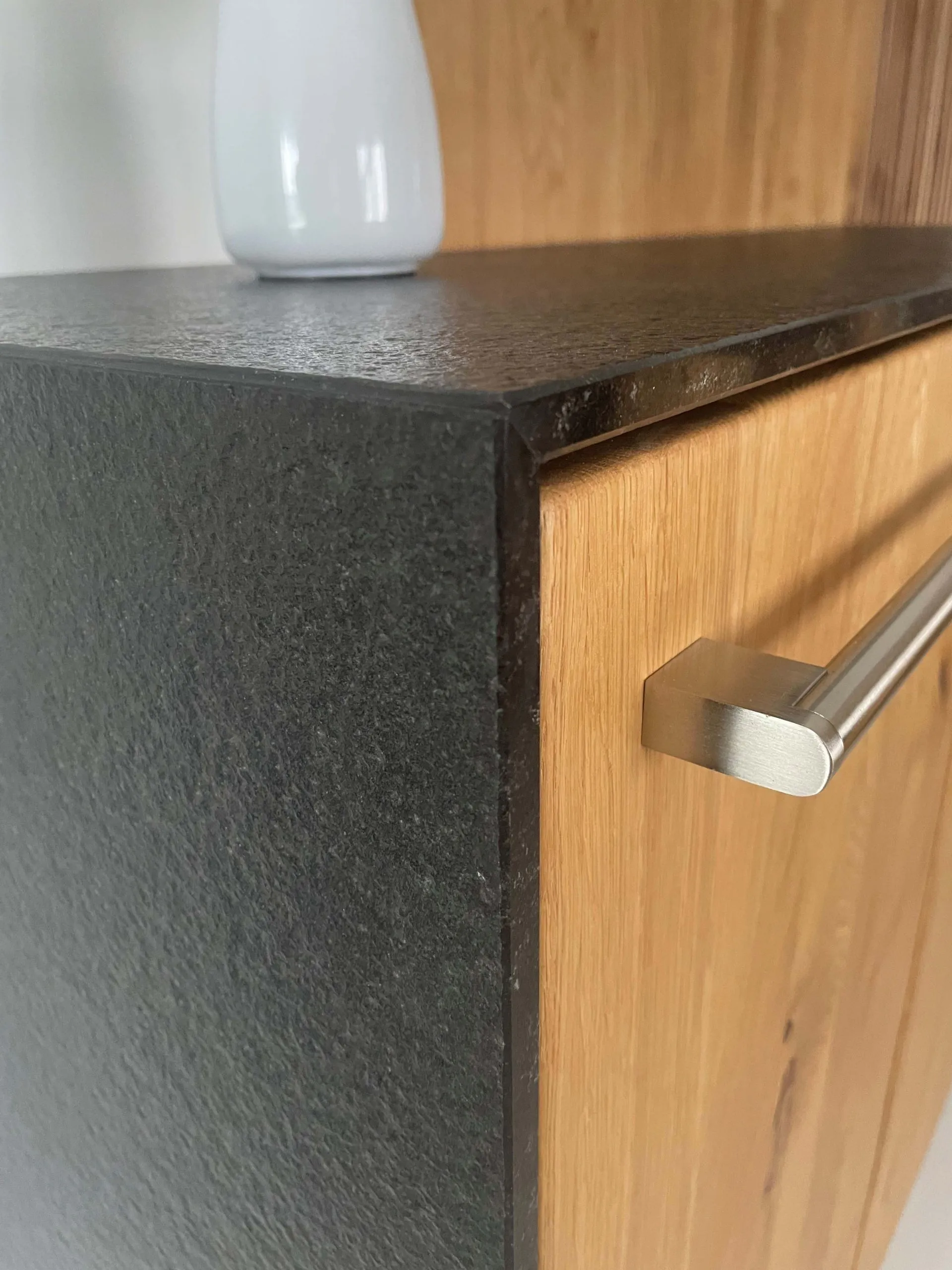 Material-Detail: Eichenholz-Schublade mit Edelstahl-Bügelgriff und dunkler Steinarbeitsplatte