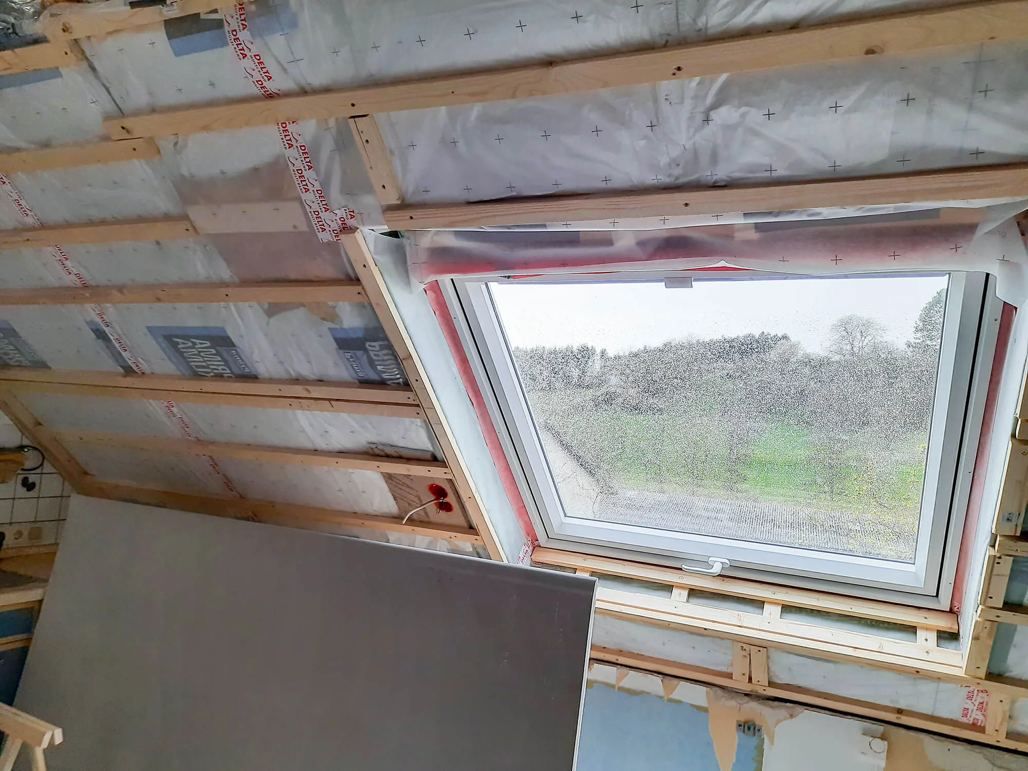 Bauphase: Rohbau mit freigelegten Dachsparren und neu eingebautem Dachflächenfenster