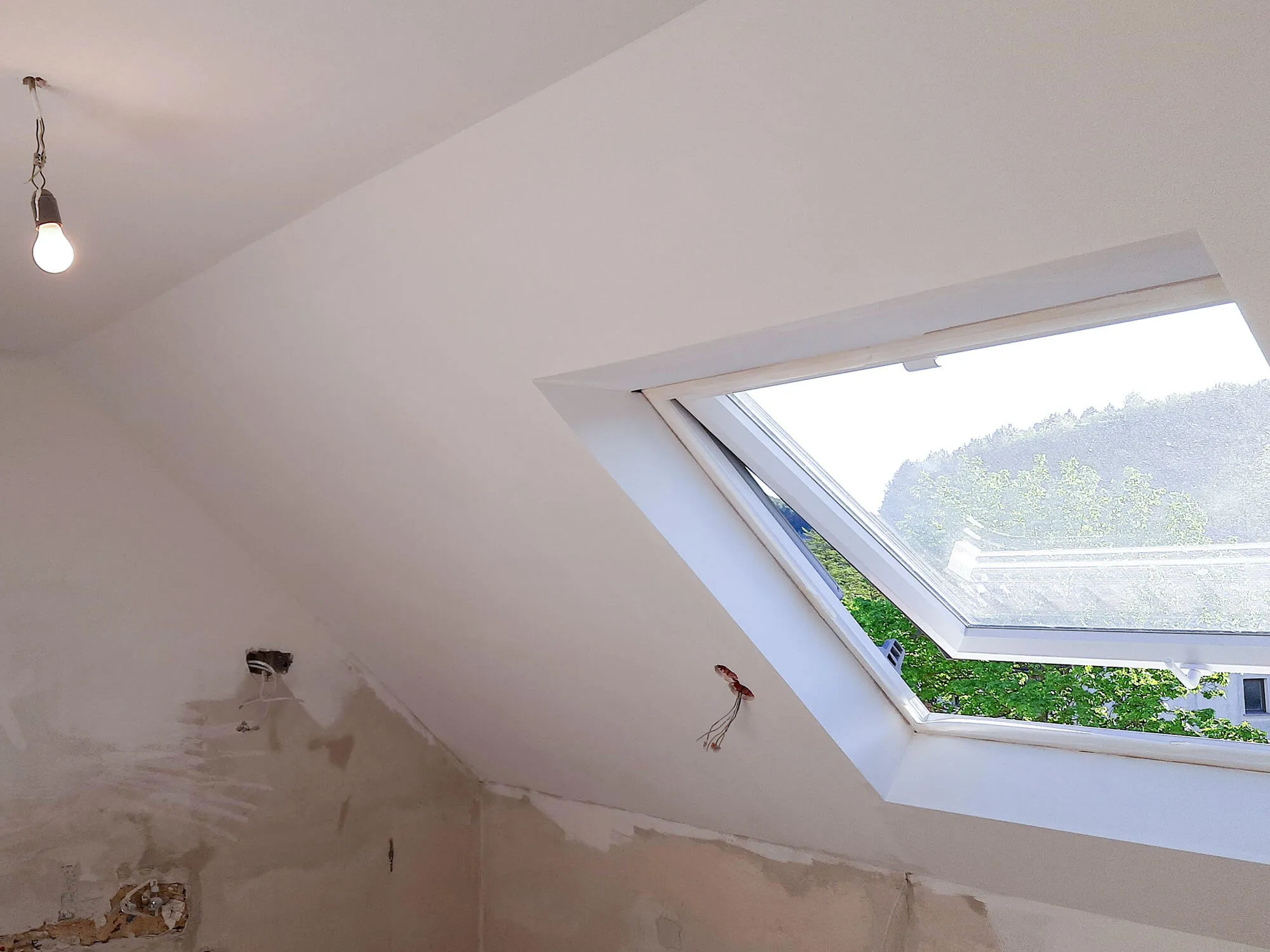 Vorher-Aufnahme: leerer Raum mit Dachschräge und Dachflächenfenster vor Küchen-Einbau