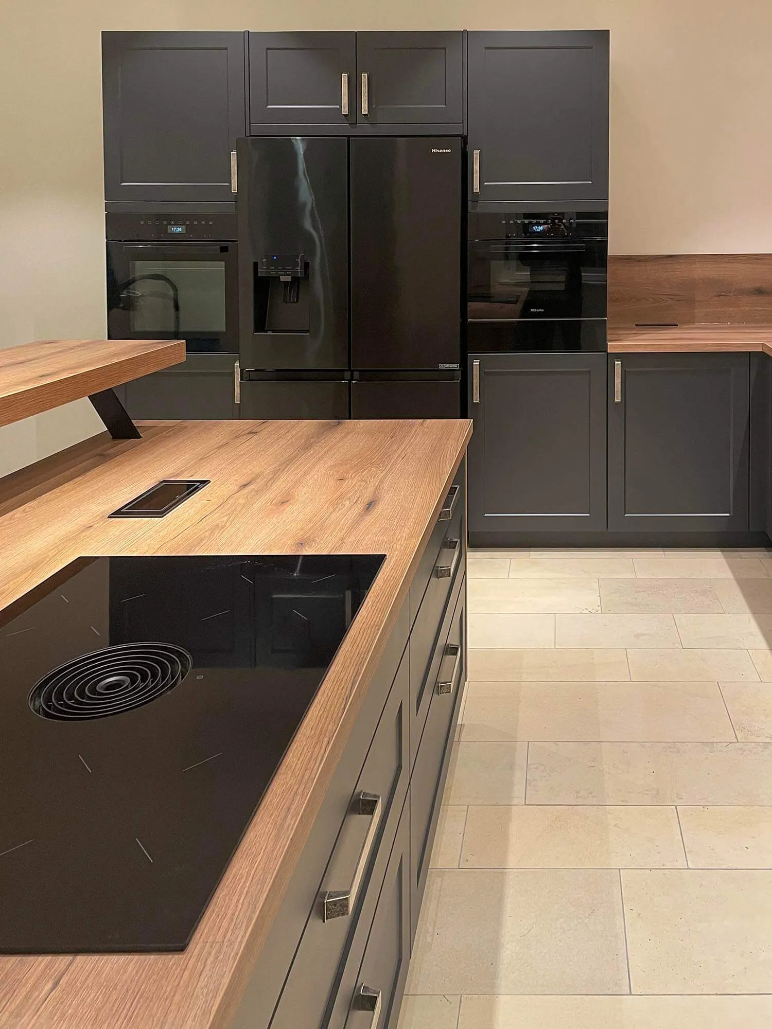 Wohnküche in Anthrazit mit Holz-Insel, Side-by-Side-Kühlschrank und zwei eingebauten Backöfen