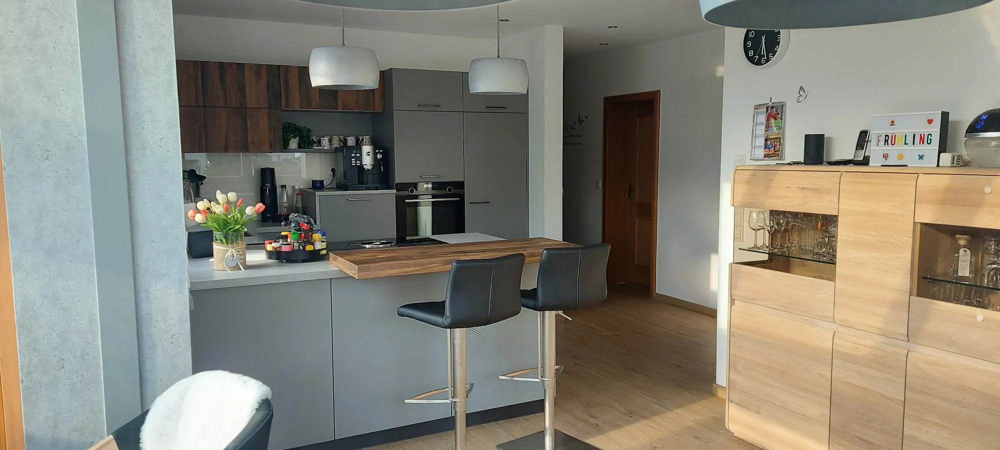 Wohnküche mit grauer Halbinsel, Holz-Hochschränken, Esstheke und Sideboard